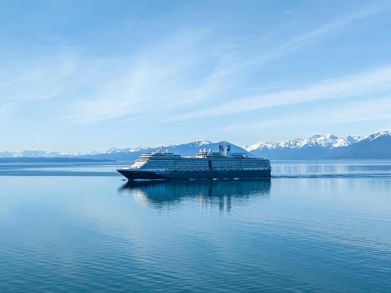 cruise ship on the ocean with icy mountains in the distance
