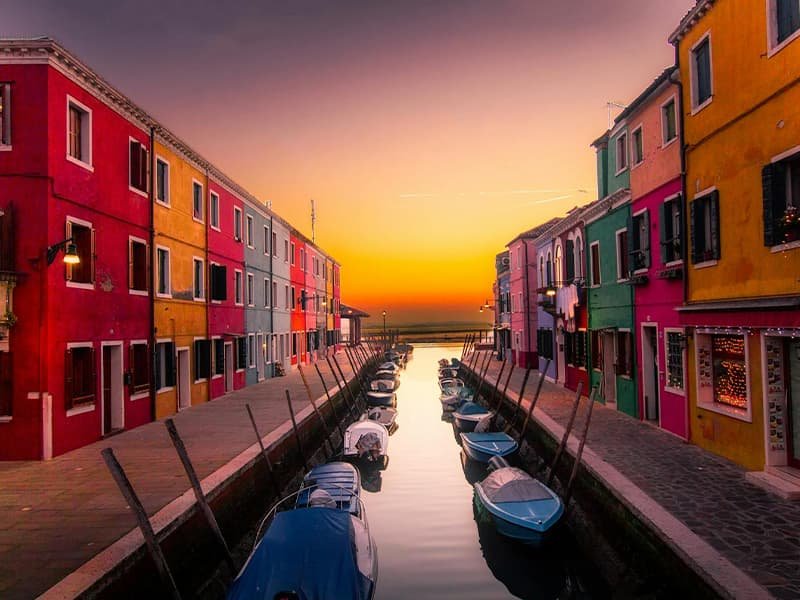 A canal between a row of homes in Burano Italy