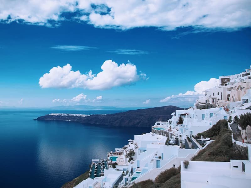 Off the coast of Greece with a view of the ocean and white buildings on a cliffside